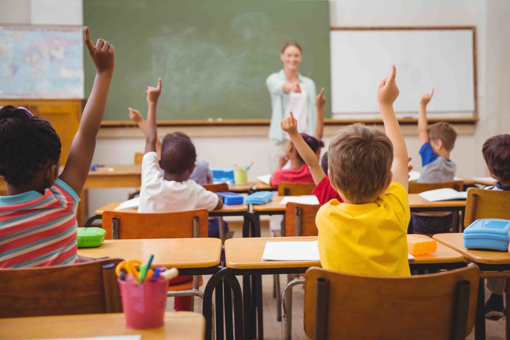 Pupils raising their hands during class